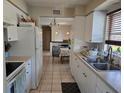 Efficient kitchen with white cabinets, stainless steel sink, and tiled flooring at 3036 Lockwood Ter, Sarasota, FL 34231