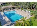 Aerial view of large pool area with tables, chairs, and lounge seating under pergolas at 3330 Thornwood Rd # 3330, Sarasota, FL 34231