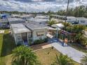 Aerial view of this property showcasing tropical palm trees, a long driveway, and a covered patio with colorful umbrellas at 4103 12Th Street E Ct, Ellenton, FL 34222