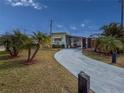 Inviting home showcasing tropical palm trees, a long driveway, and a covered patio for outdoor relaxation and enjoyment at 4103 12Th Street E Ct, Ellenton, FL 34222
