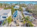 Aerial shot of a charming two-story yellow home with mature landscaping and stunning water views in a desirable location at 4117 Roberts Point Cir, Sarasota, FL 34242