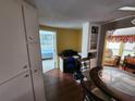 View of the kitchen with wood floors, leading to a bedroom and the living room at 415 Dublin Ave, Bradenton, FL 34207
