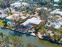 Aerial view of the waterfront home featuring a pool, dock, and canal access at 5073 Higel Ave, Sarasota, FL 34242