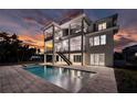 A back exterior view of a multi-story home featuring a private pool and patio area, perfect for outdoor entertainment at 597 Buttonwood Dr, Longboat Key, FL 34228