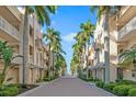 Charming street view lined with palm trees and beautiful condo buildings under a clear blue sky at 5970 Midnight Pass Rd # 177, Sarasota, FL 34242