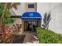 Inviting building entrance features a blue awning and well-maintained landscaping at 6120 43Rd W St # 103B, Bradenton, FL 34210
