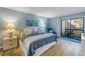 Cozy main bedroom with light blue walls, comfortable furnishings and access to the balcony at 6120 43Rd W St # 103B, Bradenton, FL 34210