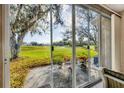 Screened-in patio with comfortable seating, potted plants, and views of golf course at 6314 Stone River Rd # 6314, Bradenton, FL 34203