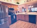 Well-lit kitchen featuring stainless steel appliances, wooden cabinets, and modern fixtures; ideal for cooking and entertaining at 6916 Stoneywalk Ct # 6916, Bradenton, FL 34203