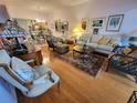 A cozy living room with hardwood floors, a comfortable sofa, stylish chairs, and decorative artwork creates a warm ambiance at 6916 Stoneywalk Ct # 6916, Bradenton, FL 34203