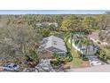 Aerial view of a single-story home near a pond, showcasing the property's landscaping and neighborhood at 7312 Eleanor Cir, Sarasota, FL 34243