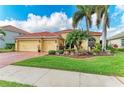 Charming home featuring a well-manicured lawn, beautiful landscaping, red-tiled roof and a three-car garage at 9039 Willowbrook Cir, Bradenton, FL 34212