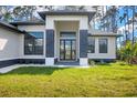 Inviting entrance with stone accents and a modern black framed front door at 12495 Patsy Ave, Port Charlotte, FL 33981