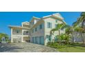 Elegant two-story home with a three-car garage, accented by blue shutters and lush landscaping at 1300 Tangier Way, Sarasota, FL 34239