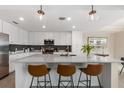 Bright kitchen featuring a large island with seating, pendant lights and modern appliances at 17704 Gawthrop Dr # 307, Bradenton, FL 34211