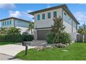 Contemporary two-story home featuring modern design, a driveway, landscaped yard, and fresh green grass at 2220 Pine Ter, Sarasota, FL 34231