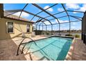 Screened-in pool and spa overlooks a tranquil lake; perfect for relaxing and entertaining guests at 26833 Weiskopf Dr, Englewood, FL 34223