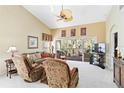 Spacious living room with vaulted ceilings, ceiling fan, comfortable seating, and a serene view of the outdoors at 306 Lynbrook Cir # 201, Venice, FL 34292