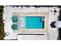 Aerial view of a modern swimming pool with stylish outdoor furniture and lush landscaping at 3228 Webber St, Sarasota, FL 34239