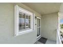 Condo entrance with white door and screen, window with white frame, and a welcome mat at 3310 Loveland Blvd # 906, Punta Gorda, FL 33980