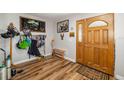 Inviting entryway with a wooden front door, hat rack, bench, and wood-look floors at 34200 State Road 62, Parrish, FL 34219