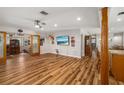 Spacious living room with hardwood floors, a ceiling fan, and a large flat-screen TV at 34200 State Road 62, Parrish, FL 34219