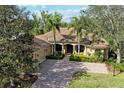 Stunning exterior elevation showcasing lush landscaping and a tile roof in a tropical setting at 3751 Eagle Hammock Dr, Sarasota, FL 34240