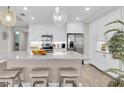 Kitchen features white cabinets, stainless steel appliances, granite countertops, a center island, and an eat-in bar at 383 Aruba Cir # 102, Bradenton, FL 34209