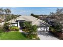 An aerial view showcases the tiled roof, pristine landscaping, and prime location of this home at 4941 Sabal Lake Cir, Sarasota, FL 34238
