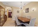 An elegant dining room featuring modern lighting, neutral walls, tile floor, and stylish decor at 5141 Lansdowne Way, Palmetto, FL 34221