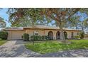 Inviting one-story home with attached garage, arched porch entryway, and a well-maintained lawn and landscaping at 515 Rousseau Dr, Nokomis, FL 34275
