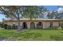 Inviting single-story home with a lovely lawn and a cozy, covered entryway framed by archways at 515 Rousseau Dr, Nokomis, FL 34275