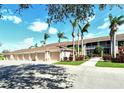 View of condo garages and units, sidewalks, mature palms and landscaping at 5320 Hyland Hills Ave # 2222, Sarasota, FL 34241