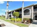 Close-up of condo building with palm trees and manicured landscaping and walkway at 5320 Hyland Hills Ave # 2222, Sarasota, FL 34241