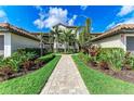 Beautifully landscaped walkway leading to a well-maintained condo building with tropical plants and manicured lawns at 5710 Palmer Cir # 204, Lakewood Ranch, FL 34211