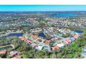 Scenic aerial view of a residential community with a mix of home styles surrounding a tranquil lake at 6911 Stetson Street Cir, Sarasota, FL 34243
