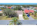 An aerial view of a well-maintained home with a two-car garage, lush lawn and mature landscaping at 6911 Stetson Street Cir, Sarasota, FL 34243