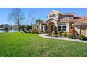 Beautiful home exterior featuring a well-maintained lawn, professional landscaping, and a tranquil pond at 6919 Winners Cir, Lakewood Ranch, FL 34202