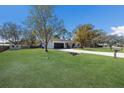 Inviting single-story home with a long driveway, lush lawn, and mature trees on a sunny day at 8108 26Th E St, Ellenton, FL 34222