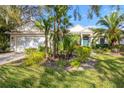 Well-maintained home exterior with an attached garage, complemented by a beautifully landscaped front yard with palm trees at 8121 Collingwood Ct, University Park, FL 34201