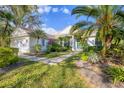 Beautiful home exterior showing a meticulously maintained lawn, mature trees, and manicured tropical landscaping at 8121 Collingwood Ct, University Park, FL 34201