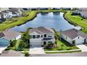Aerial view of a beautiful two-story home on a lush lot with a serene pond backdrop at 12716 Dusty Trail Dr, Sarasota, FL 34238
