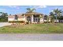 Charming home boasts lush landscaping, a neutral color scheme, and lovely architectural detailing at 17368 Norseman Ave, Port Charlotte, FL 33948