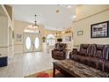 Inviting living room with wood-look floors, high ceilings, and a stylish leather furniture set at 17368 Norseman Ave, Port Charlotte, FL 33948