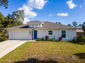 Charming single-story home featuring a blue front door, well-manicured lawn, and attached two-car garage at 1864 Nardello Ave, North Port, FL 34288