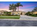 Charming single-story home at dusk featuring manicured landscaping, a tile roof and attached two-car garage at 2304 Silver Palm Rd, North Port, FL 34288