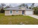 Charming single-story home with a manicured lawn and a driveway leading to a two-car garage at 3267 N Chamberlain Blvd, North Port, FL 34286