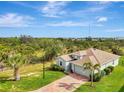 Aerial view of a well-maintained one-story home, complemented by a brick driveway and mature landscaping at 3631 Pebble Ter, Punta Gorda, FL 33980