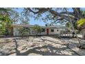 Desirable single-story home with a covered carport, complemented by mature landscaping and a pop of color on the front door at 514 Ralph St, Sarasota, FL 34242