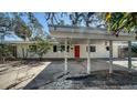 Attractive single-story home featuring a convenient covered carport, inviting curb appeal, and a welcoming red front door at 514 Ralph St, Sarasota, FL 34242